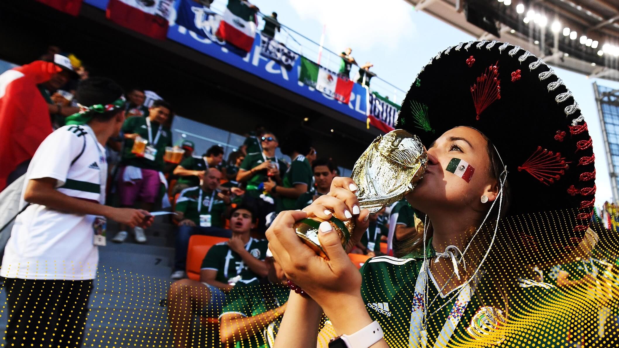 Mexican football fan in a sombrero kissing a fake world cup