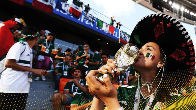 Football fan kissing the world cup in a sombrero