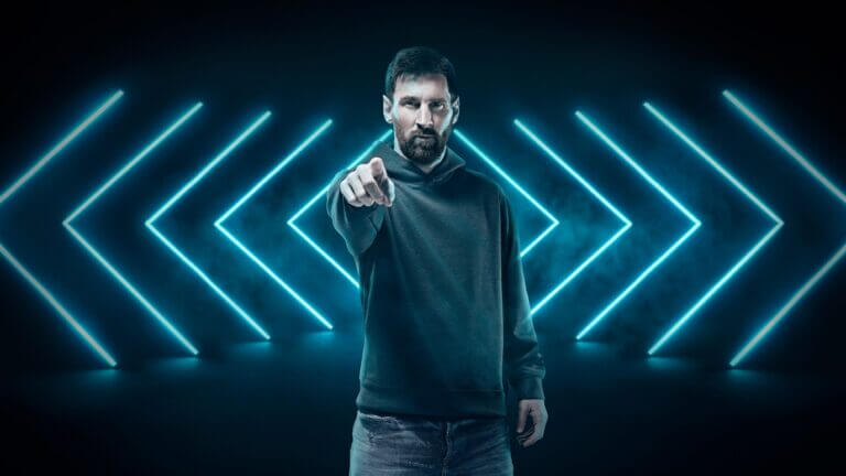 Messi in a hoodie pointing at a camera