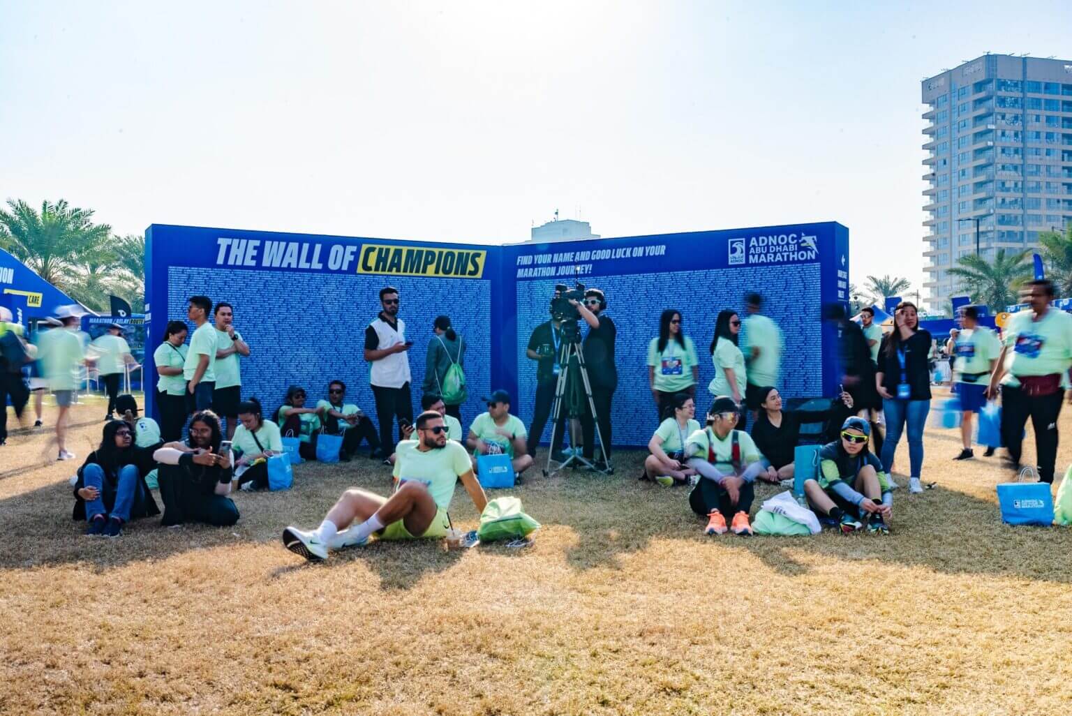 Abu Dhabi Marathon participants sit in front of the Champions wall.